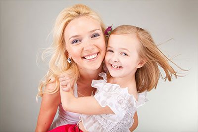 smiling girl & mother due to preventive dentistry